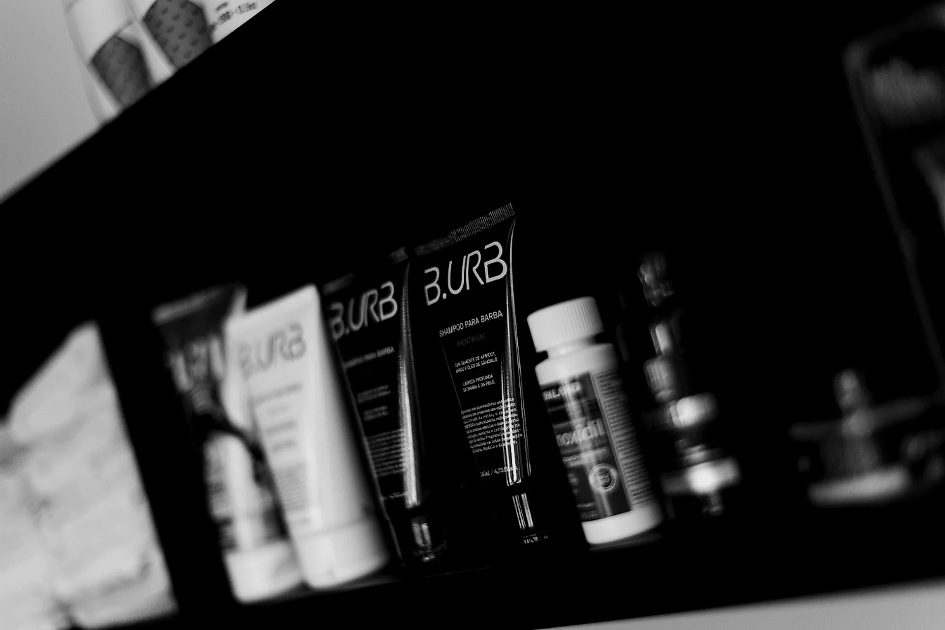 Prateleira de produtos de barbearia iluminada na parede escura do salão