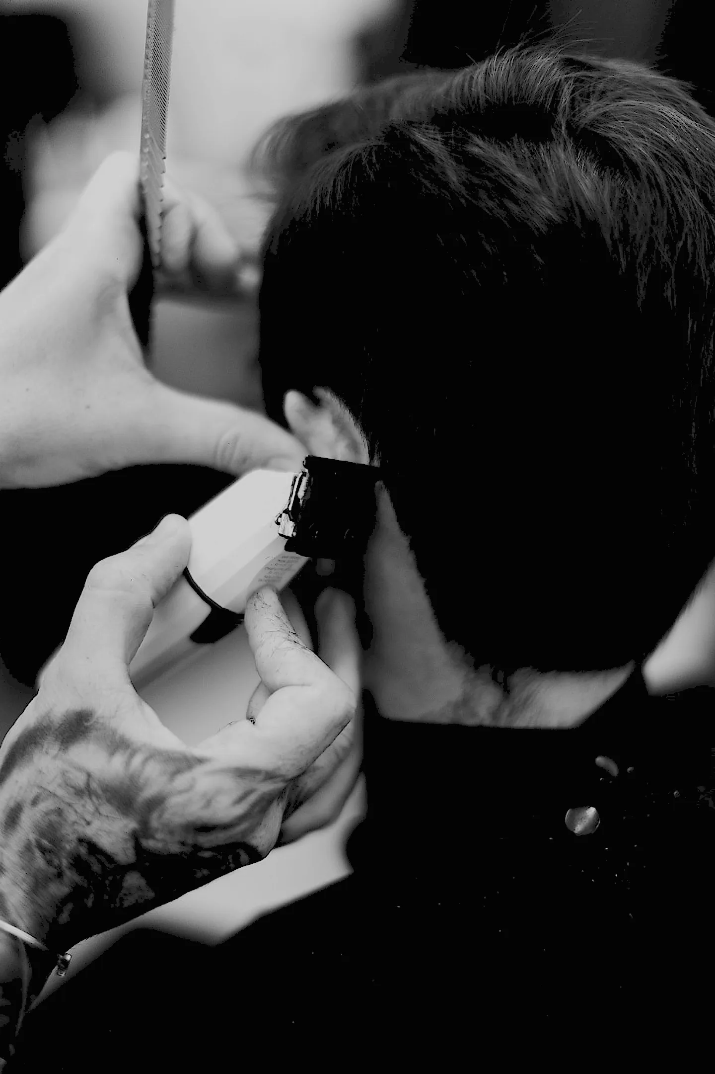 Barbeiro cortando o cabelo do cliente com tesoura e pente na cadeira da barbearia