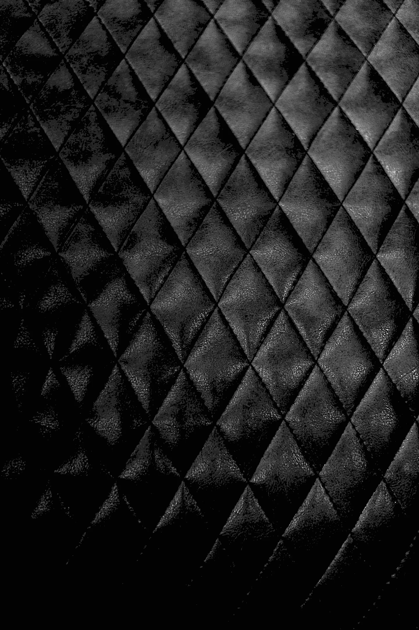 Detalhe do estofado capitonê preto da cadeira de barbeiro
